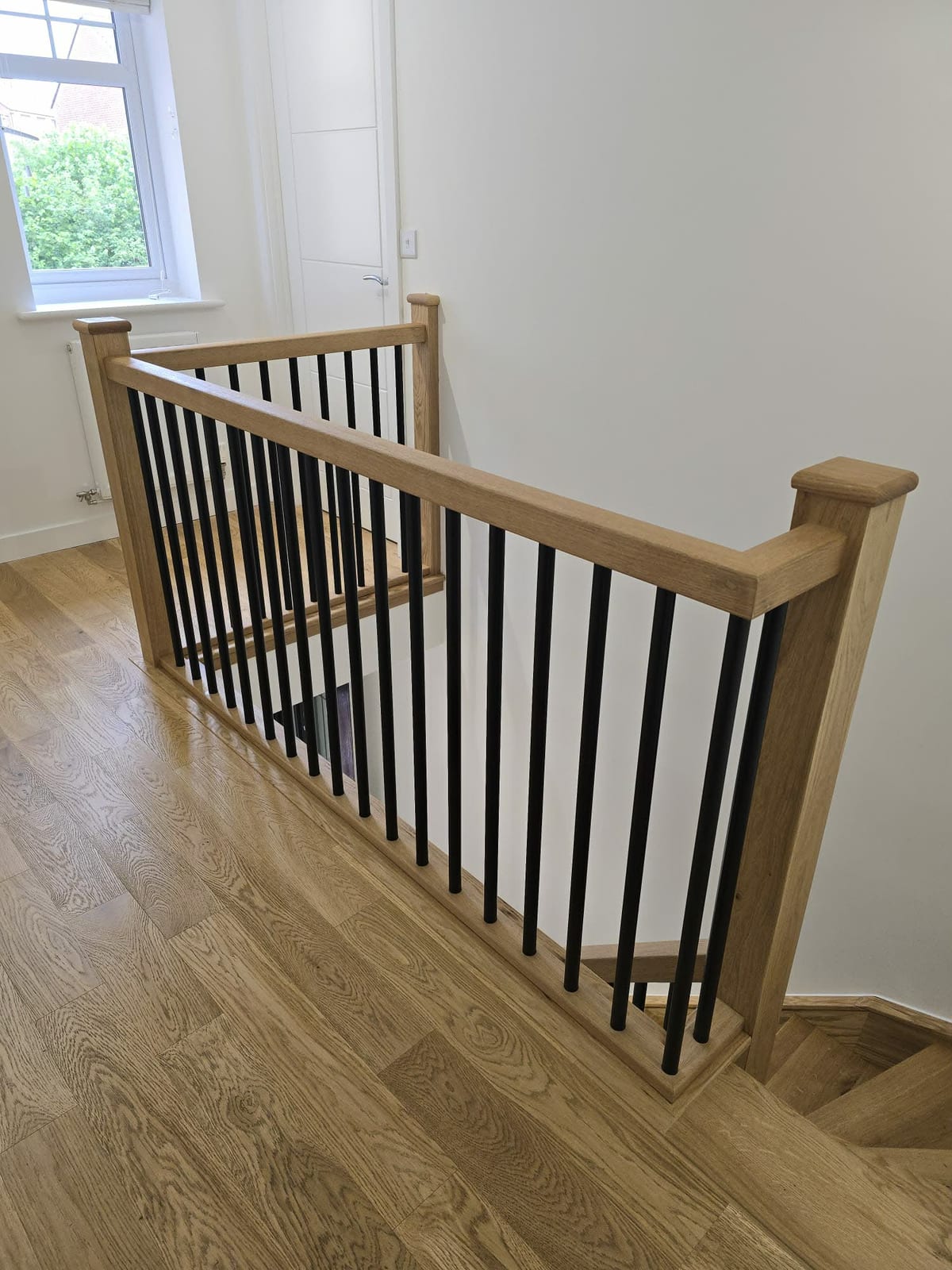 Glass panel balustrade with an oak handrail fitted to a staircase