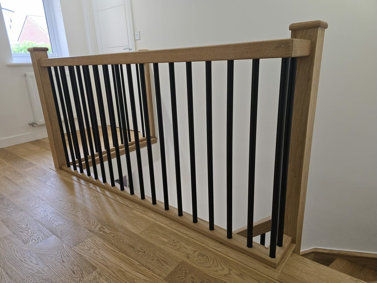 Landing balustrade in solid oak with a rounded newel cap