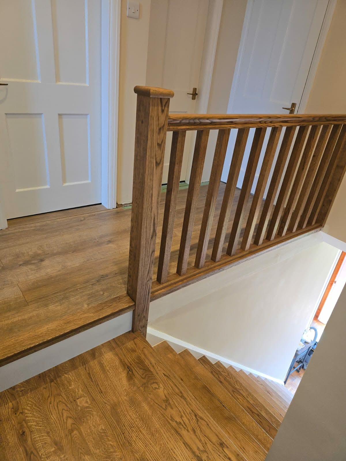 Half-landing balustrade in solid oak with black powder-coated spindles