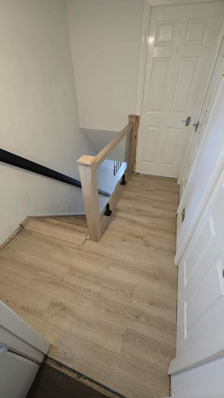 Oak staircase balustrade with black metal spindles and a solid oak handrail