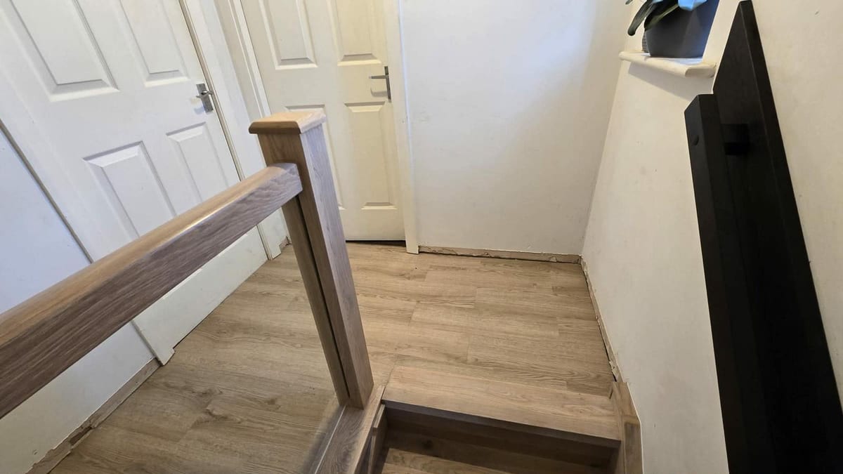 Oak handrail and metal spindle balustrade viewed from below the stairs