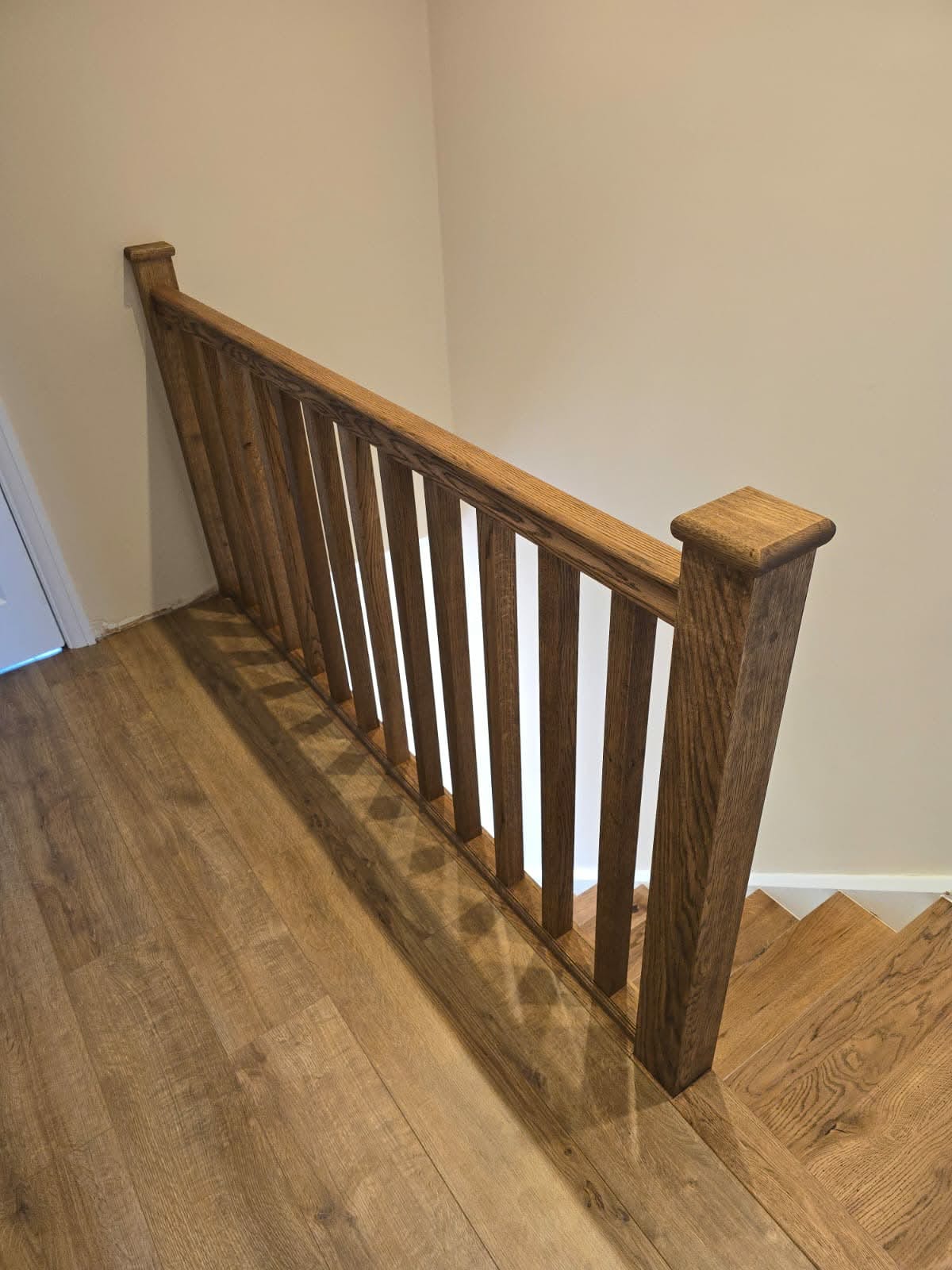 Half-landing balustrade in solid oak with black powder-coated spindles