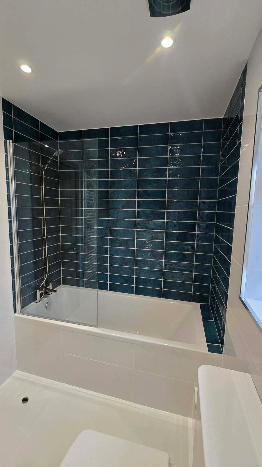 Bathroom fit-out with marble-effect tiling and illuminated mirror