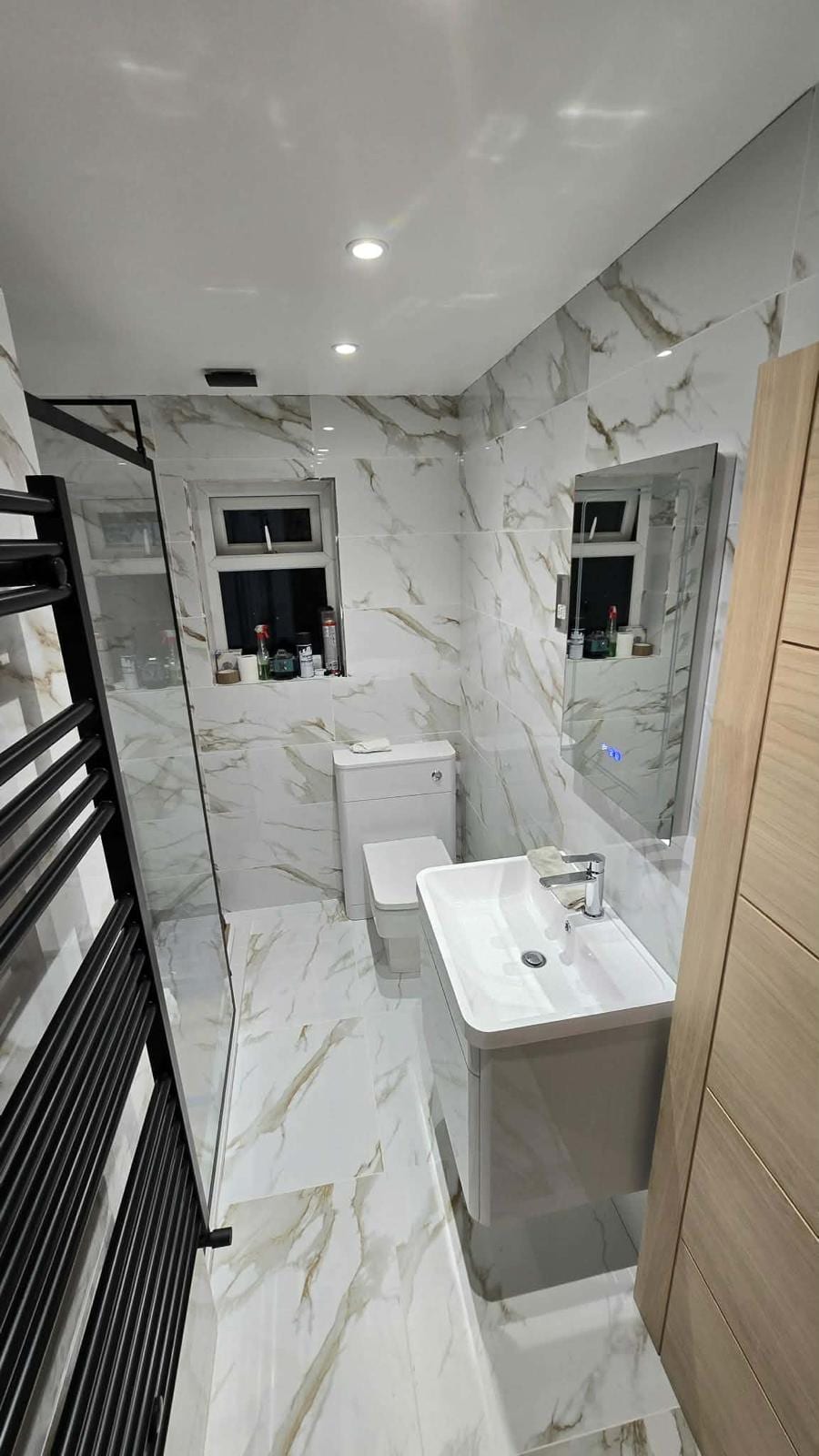 Full bathroom fit-out with a marble-effect tiled shower enclosure