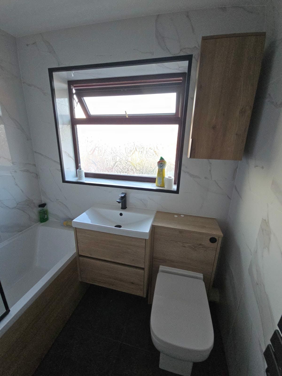 Oak vanity unit, sink and toilet fitted beneath the bathroom window