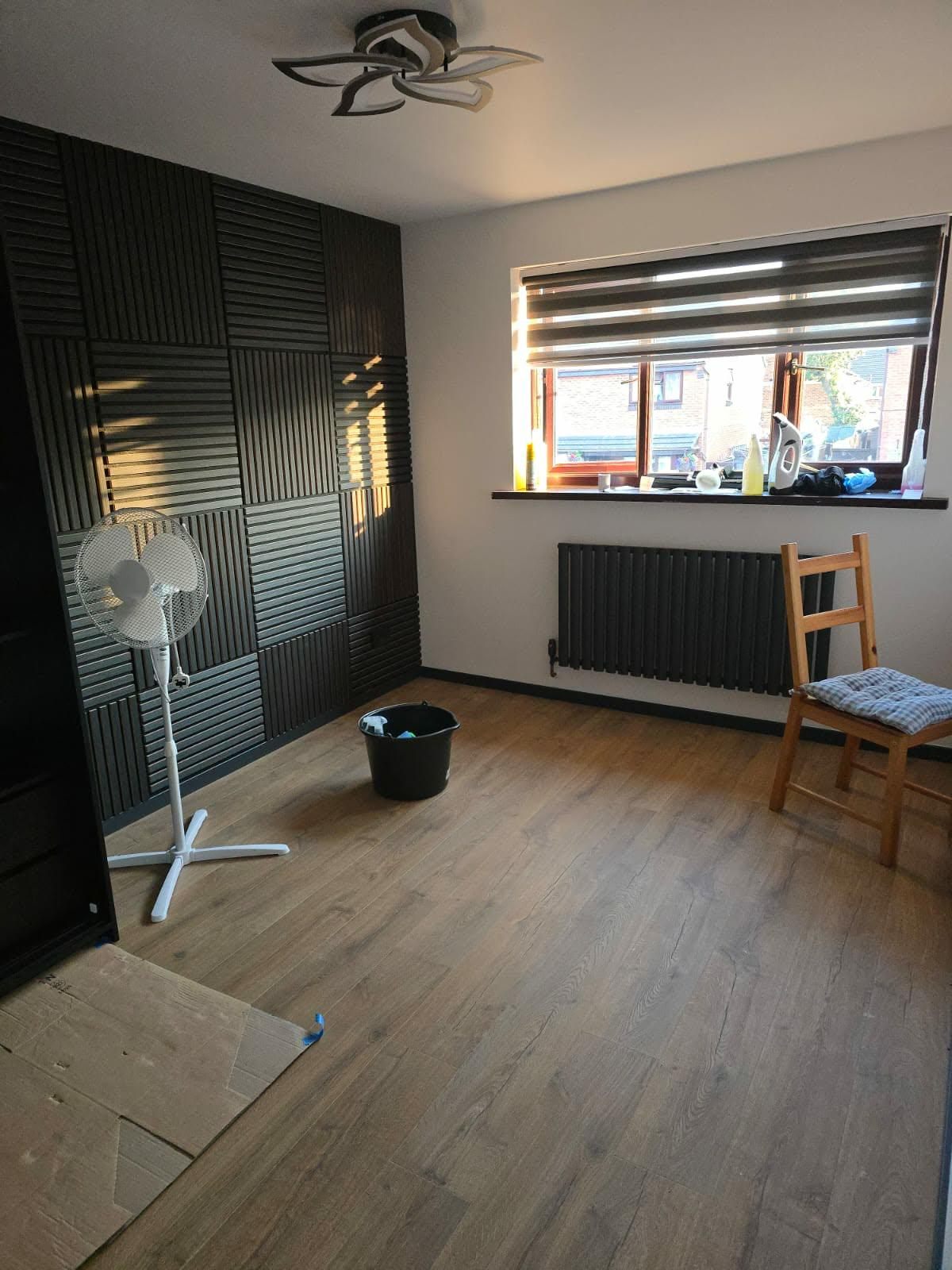 Oak-effect flooring fitted throughout a bedroom, nearing completion