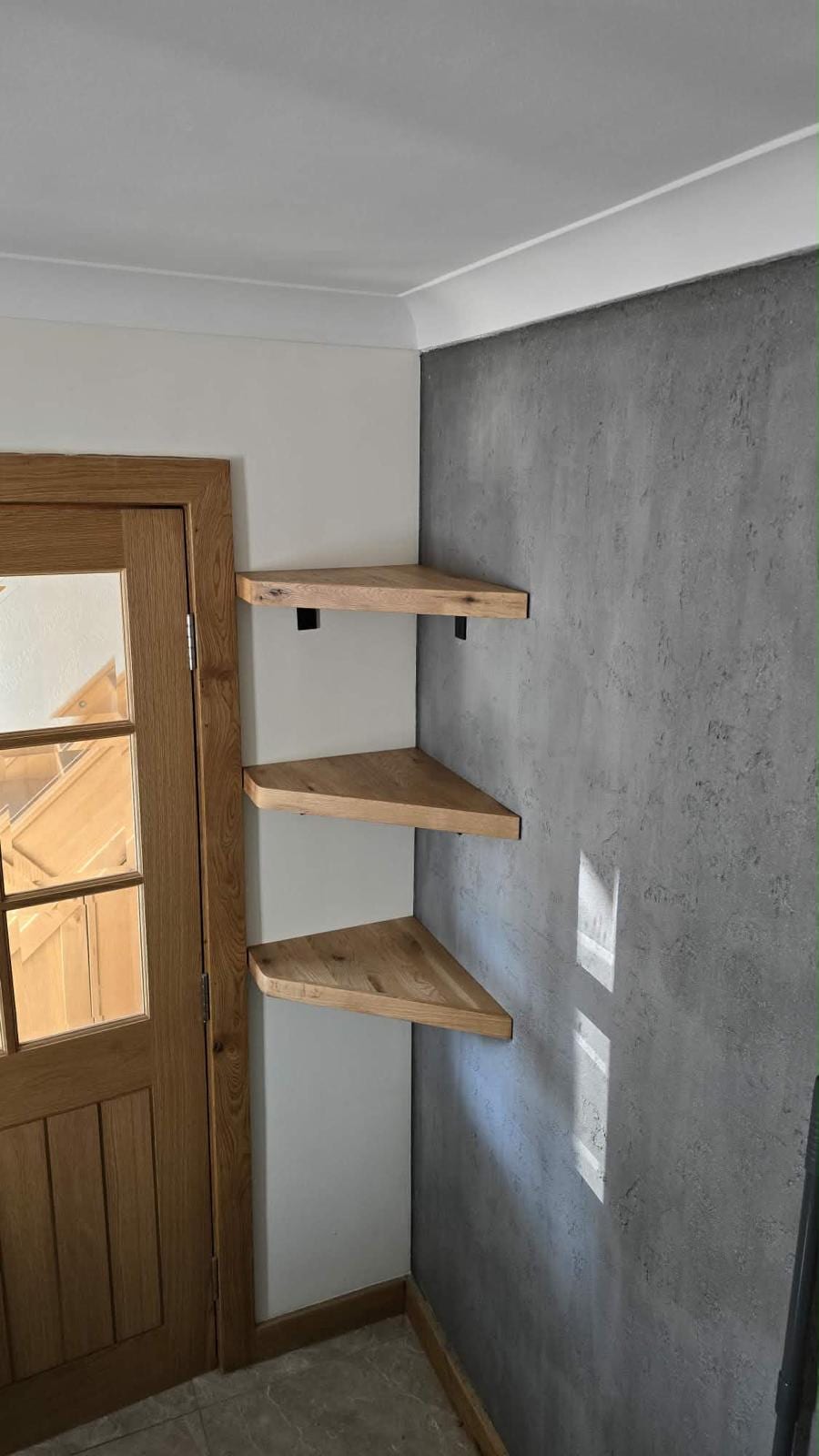 Made-to-measure oak shelving fitted into an alcove