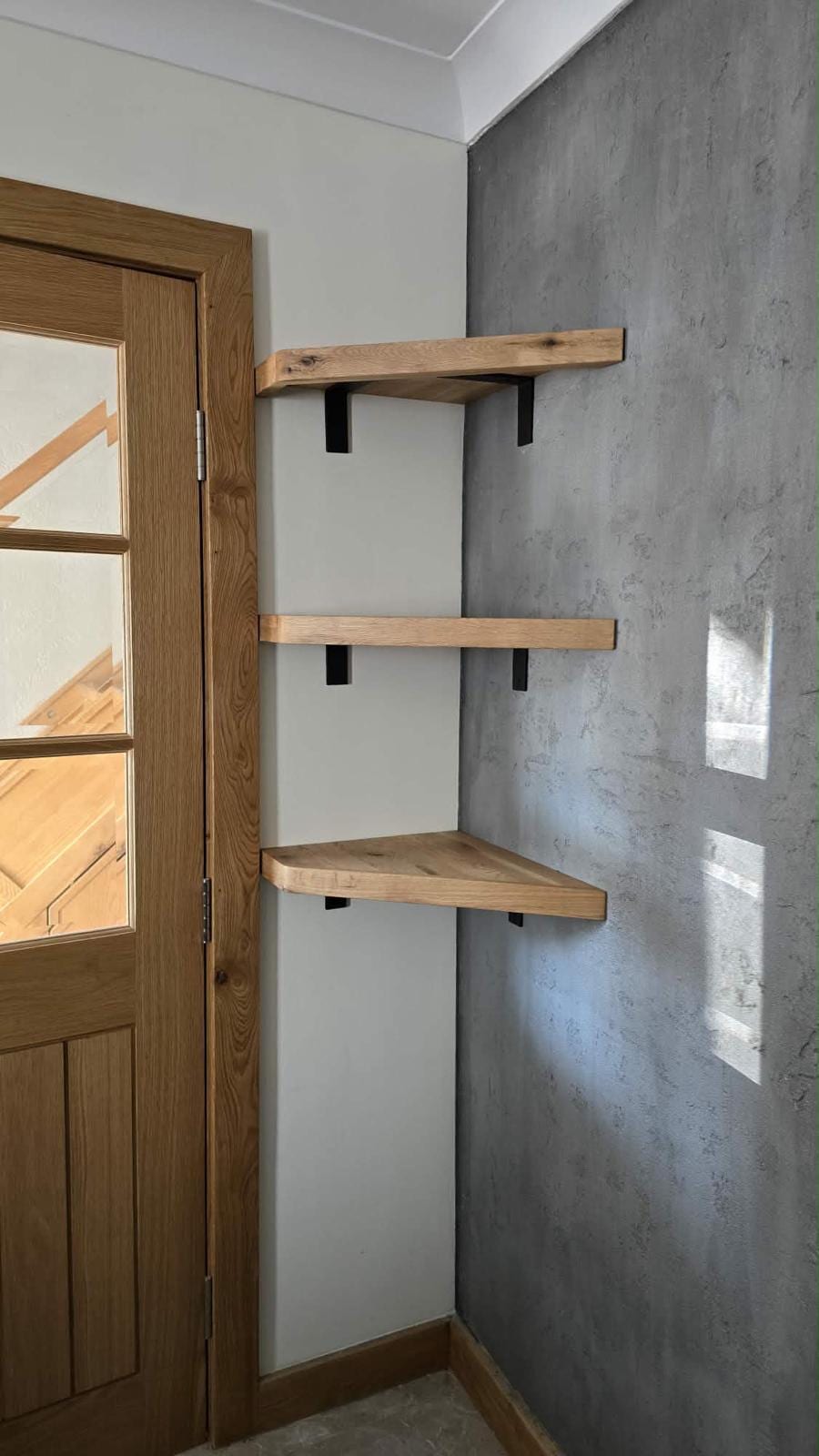 Bespoke oak shelving fitted into a chimney breast recess
