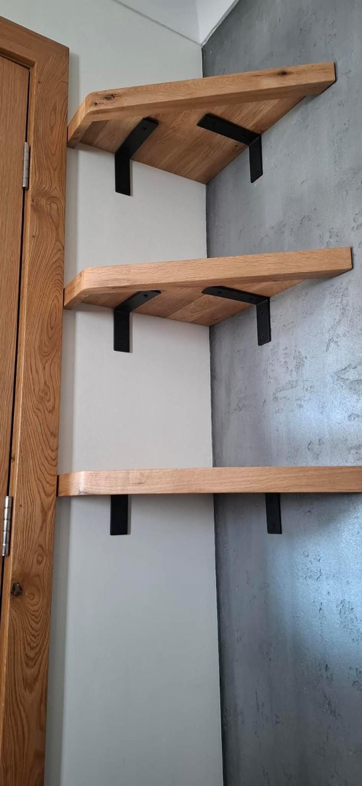 Floating oak shelves fitted in a living room alcove
