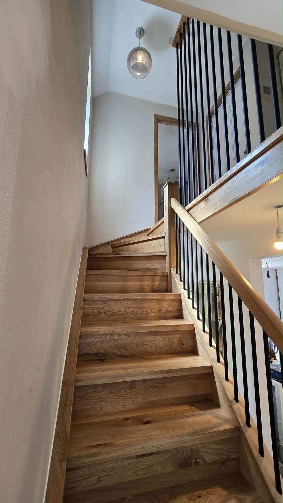 Solid oak staircase with black metal spindle balustrade, full run