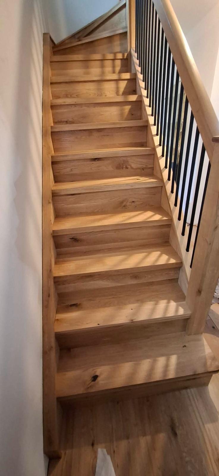 Oak staircase overlay and matching skirting fitted in a hallway renovation
