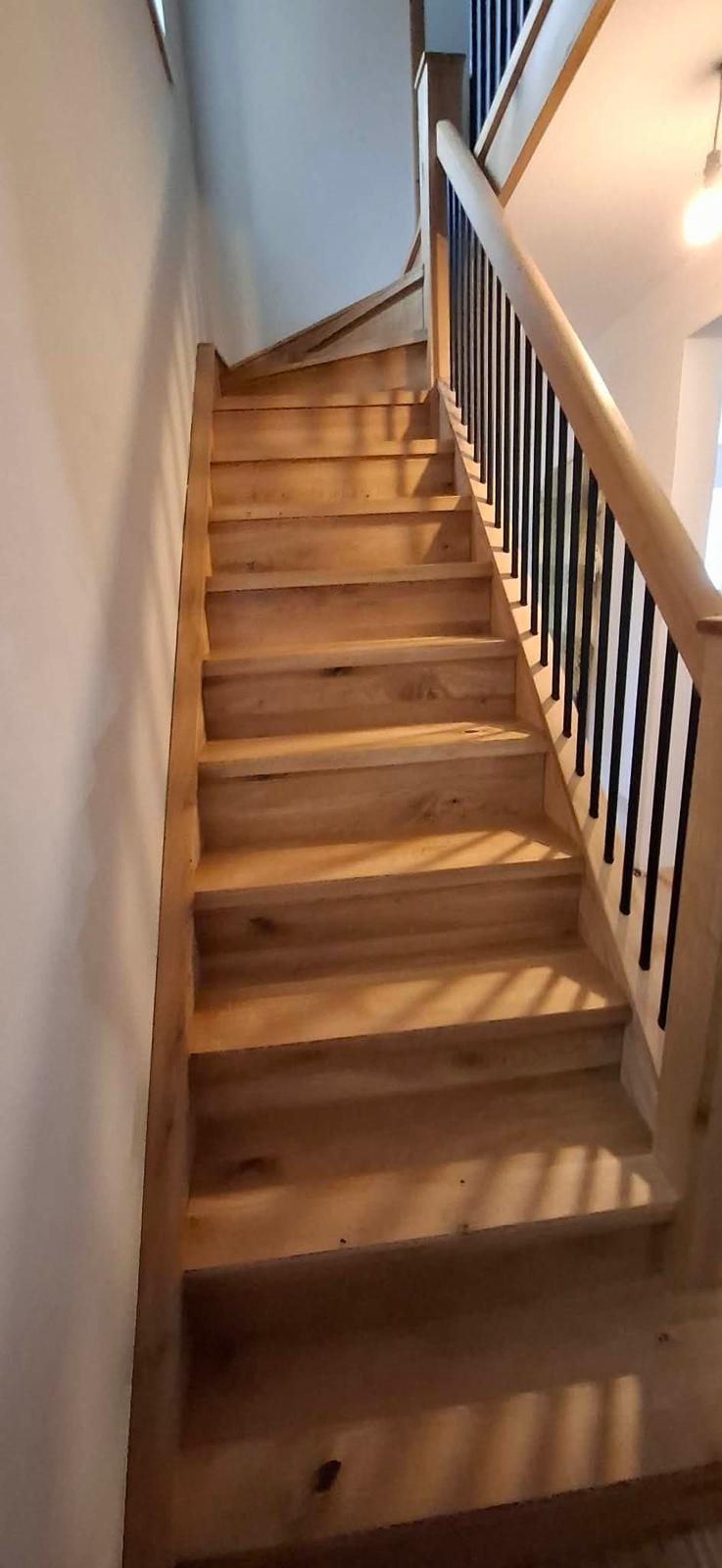 Close-up of oak stair tread grain and nosing detail on a completed overlay