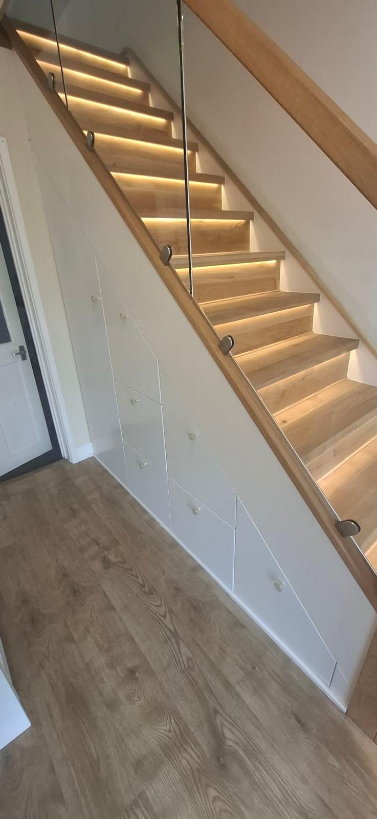 Fitted under-stair cupboards built into a staircase void